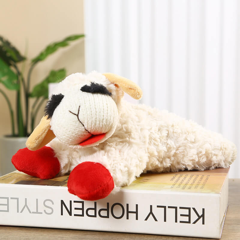 Cream lamb plush dog toy with red feet on white background