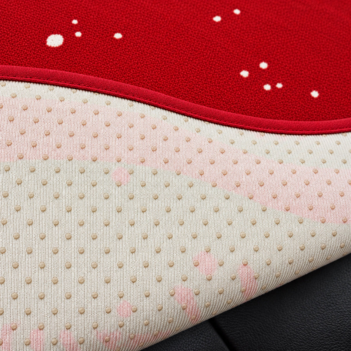 Close-up of the red Christmas sofa cover with its dotted non-slip backing