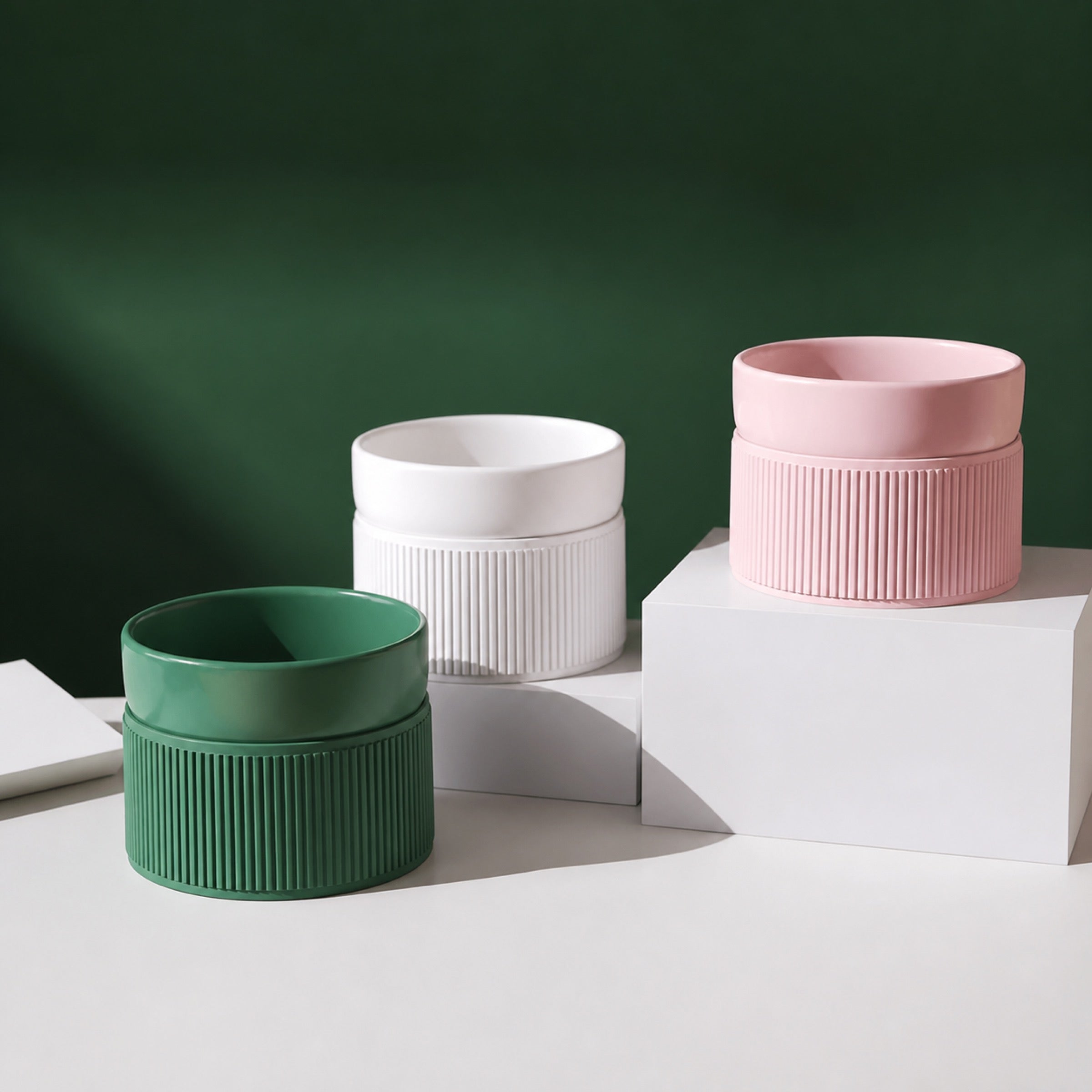Elevated ceramic pet bowls in green white and pink on studio blocks